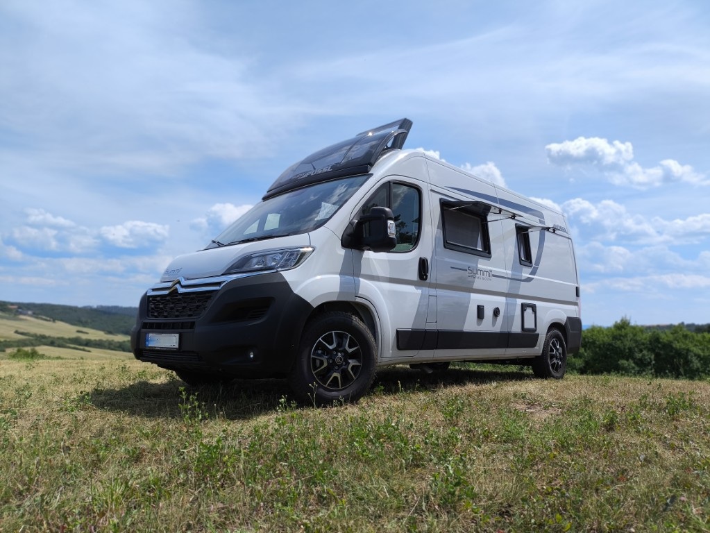 Pössl Summit 600 Prime – přední pohled, Sky Roof otevřený, dramatická obloha